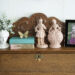 Vintage secretary desk styled with a bust, French figurines, books, a butterfly, and a picture frame