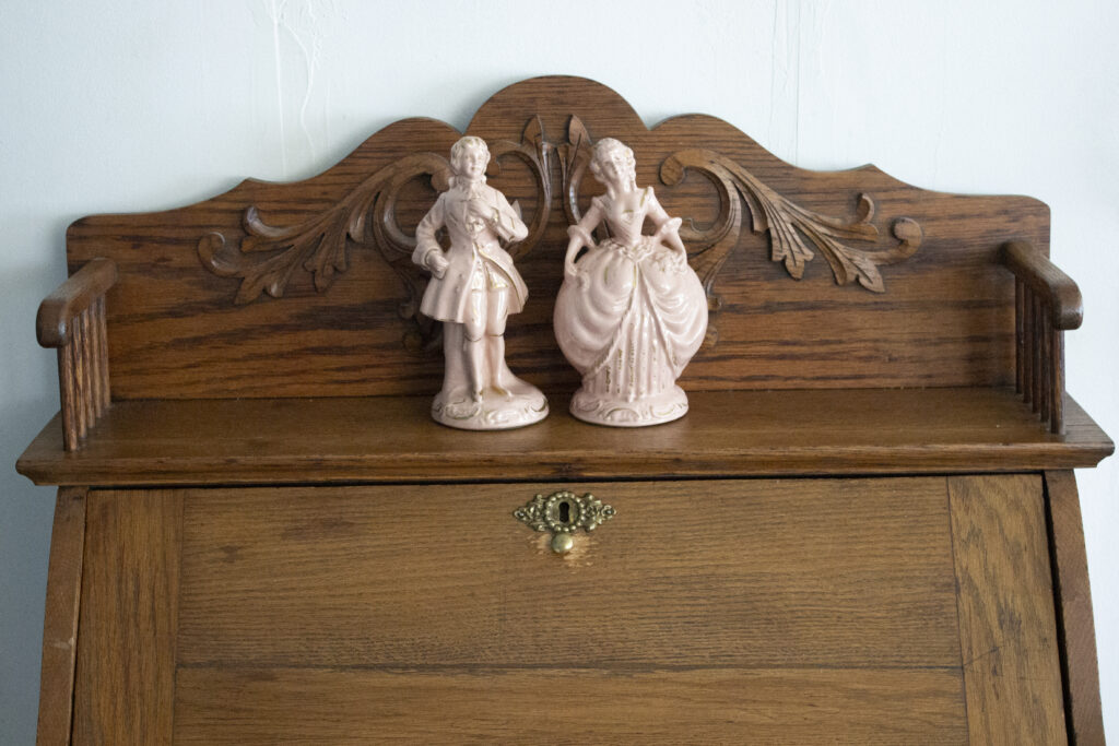 Vintage secretary desk styled with a pair of French figurines