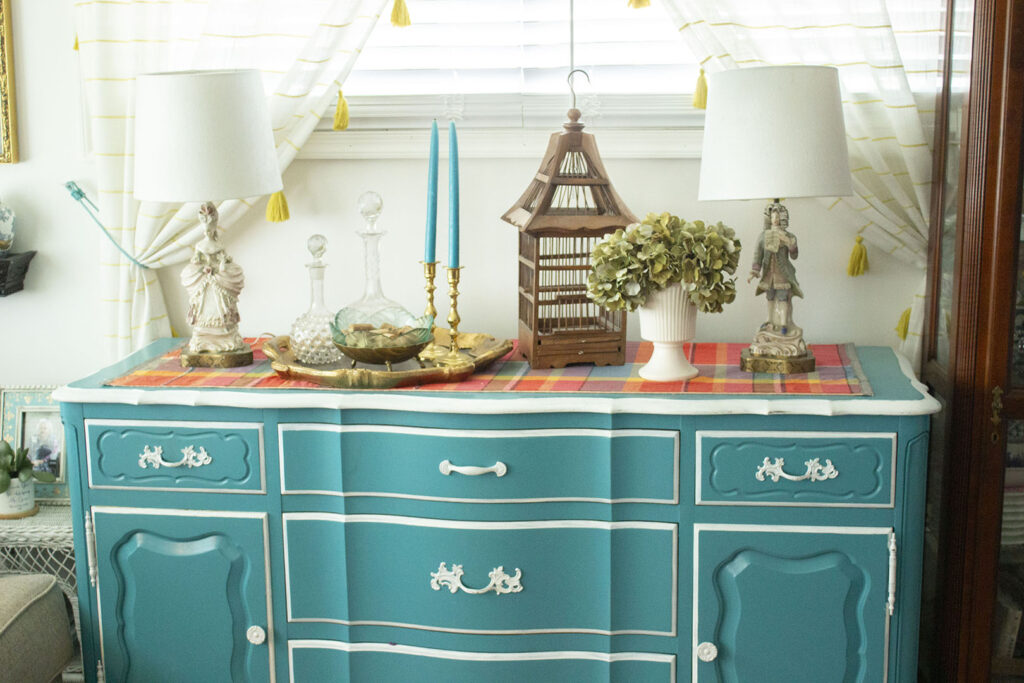 Turquoise blue buffet table  styled with French figurine lamps, hydrangeas, and a bird cage