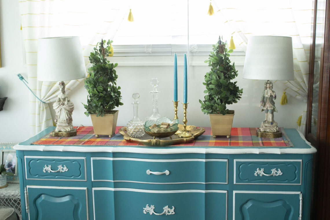 Turquoise blue buffet table styled with French figuring lamps and topiaries