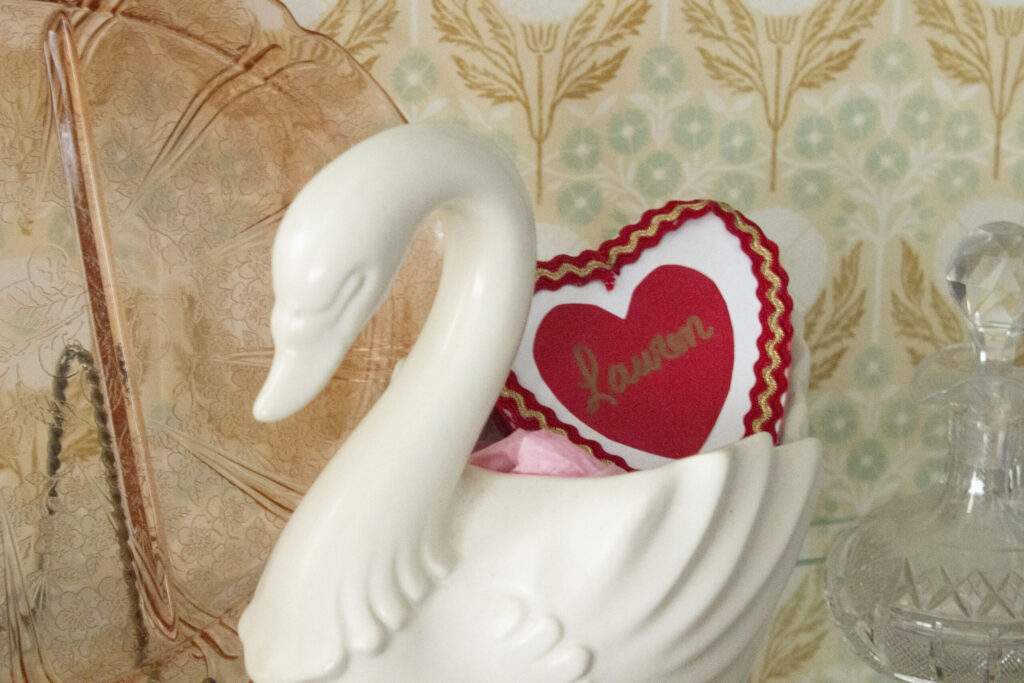 decorate for Valentine's Day: swan vase with a red heart box inside