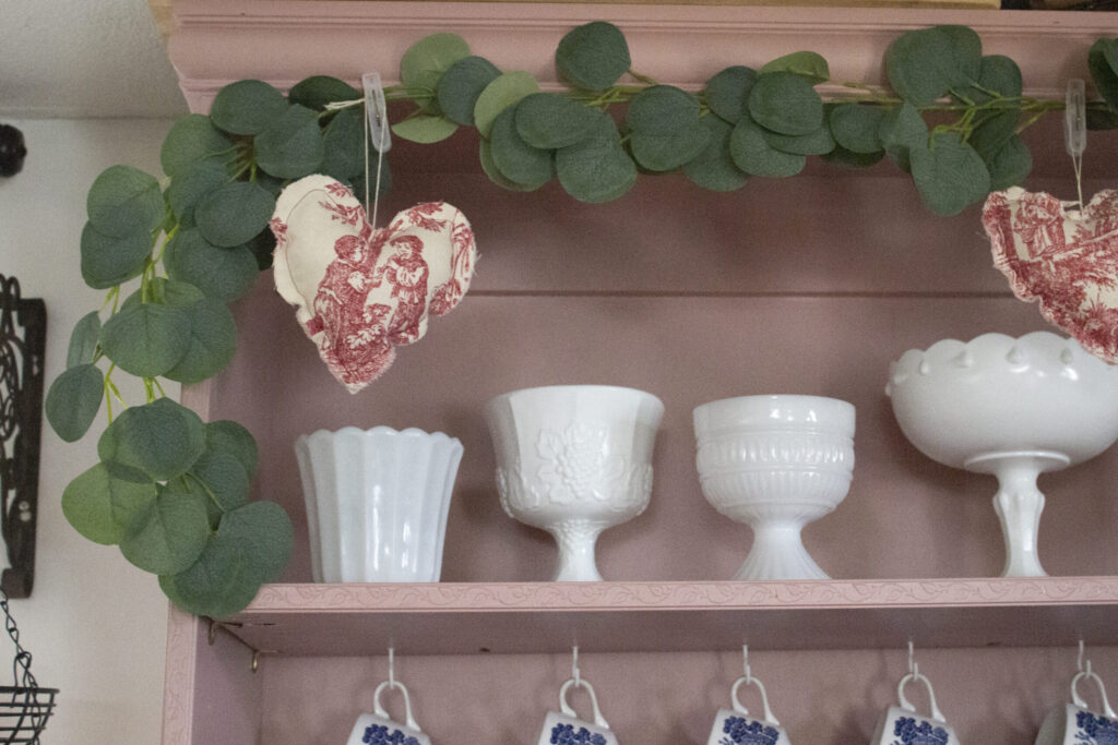 Decorate for valentine's day: eucalyptus garland and collection of milk glass