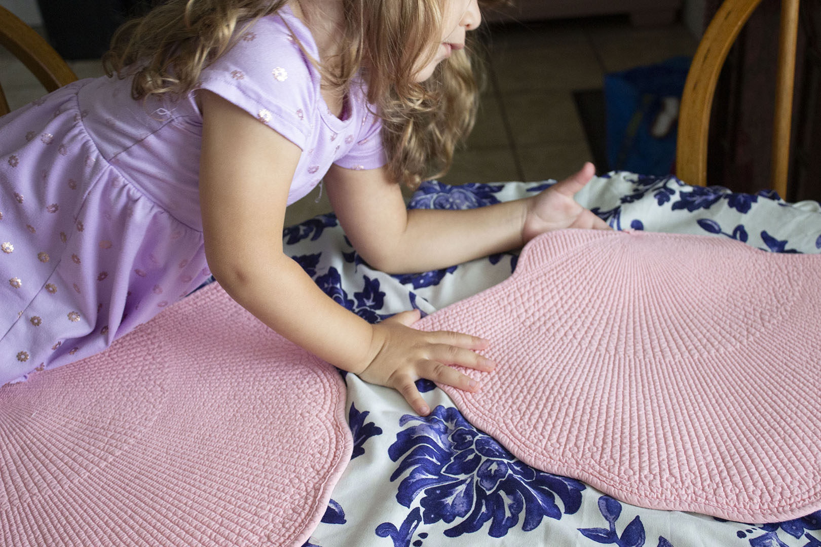 Little girl holding a pink placemat