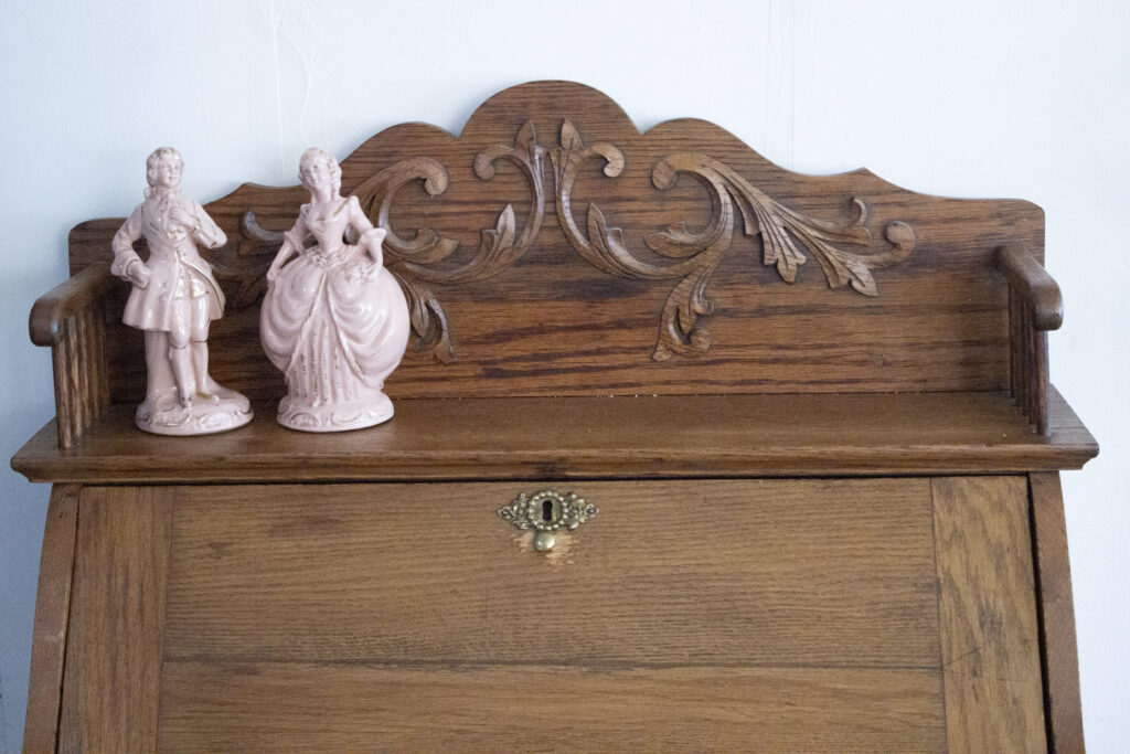 Vintage secretary desk styled with a pair of French figurines