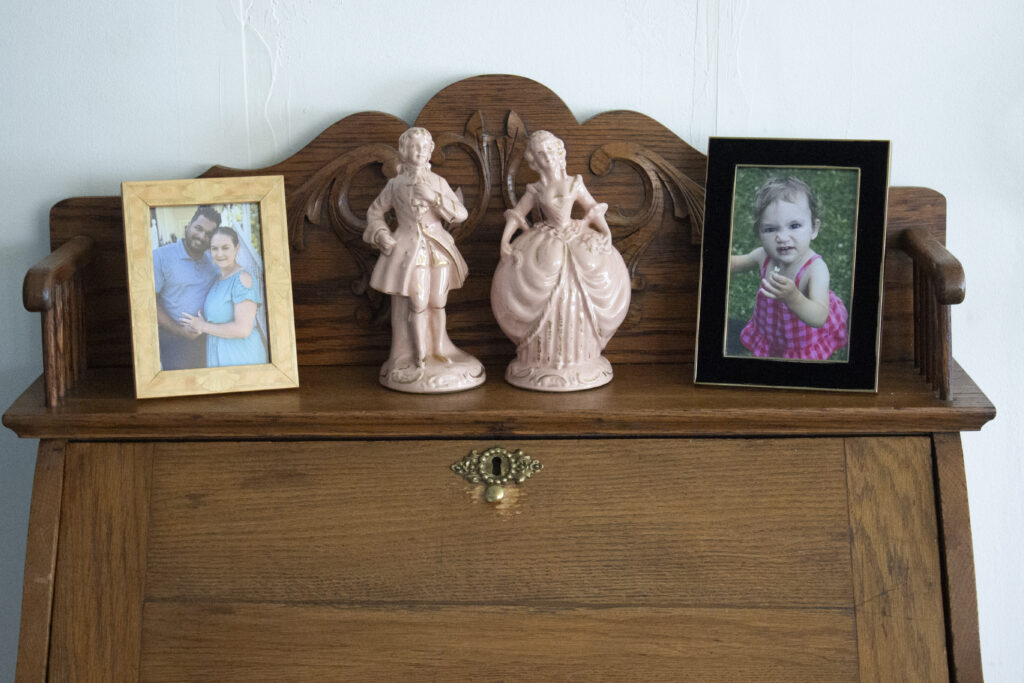 Vintage secretary desk styled with a pair of French figurines and two photo frames