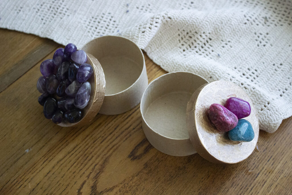 Two small boxes with colorful rocks on top