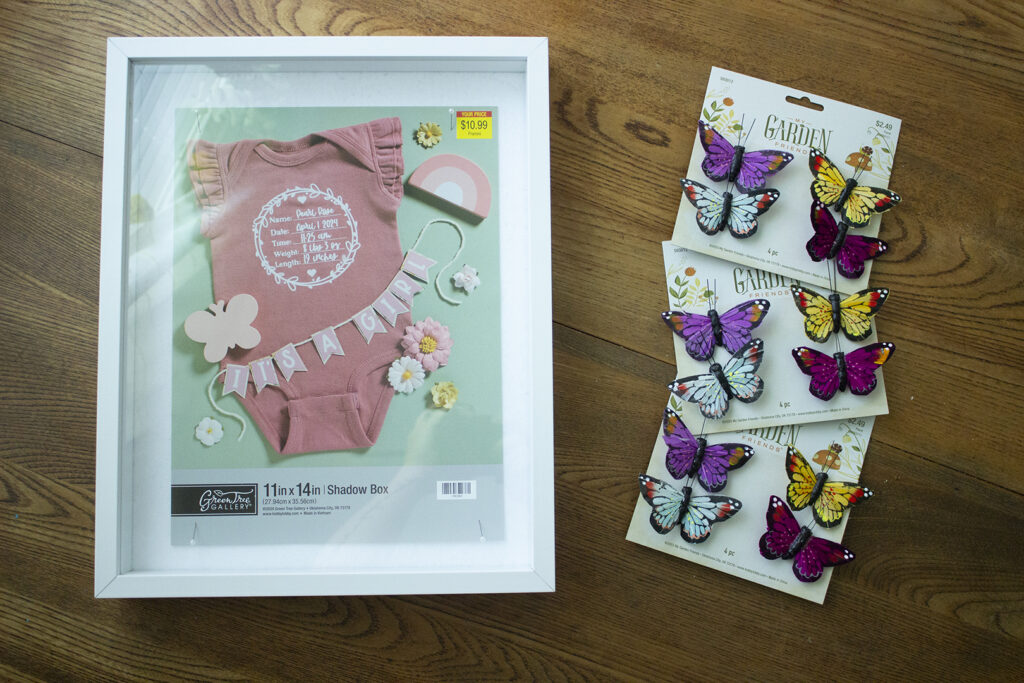 White shadowbox with a collection of colorful faux butterflies