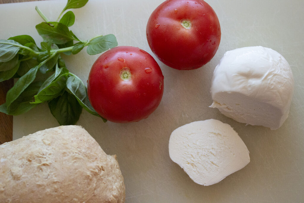 What to Do With Fresh Basil: Basil, Tomatoes, Mozarella, and loaf of bread