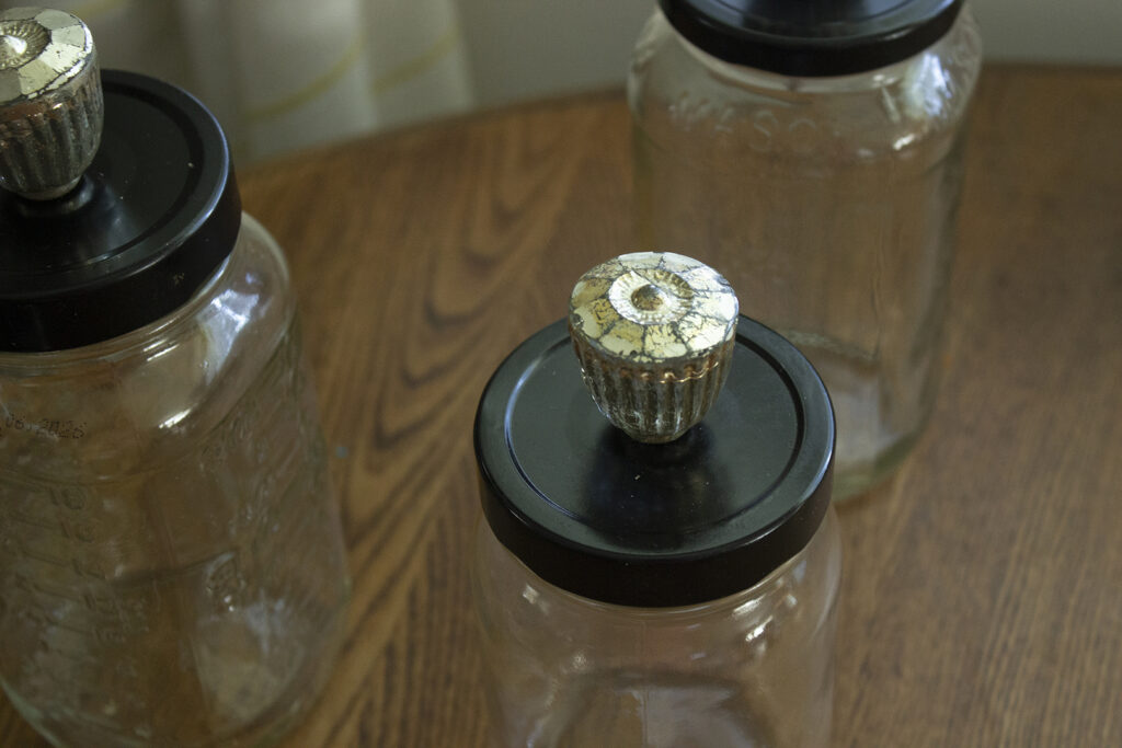 Closeup of gold knob on the lid of a glass jar