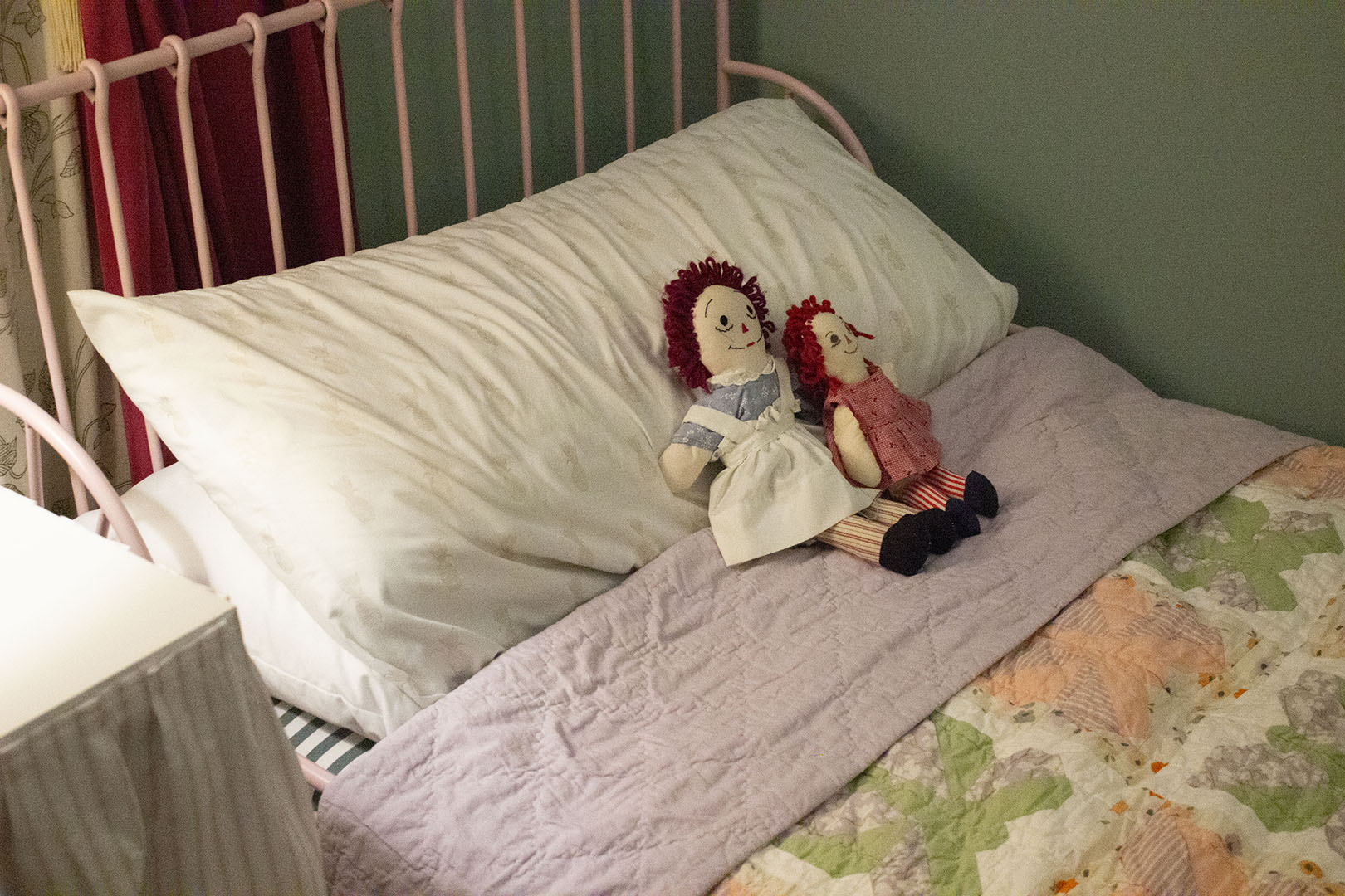 toddler bed with raggedy ann dolls lying on top